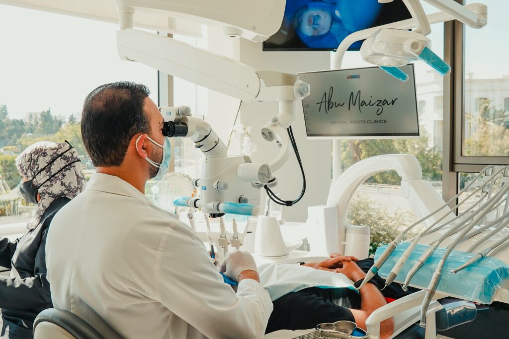 د.حسن أبوميزر أثناء إجراء علاج العصب تحت الميكروسكوب